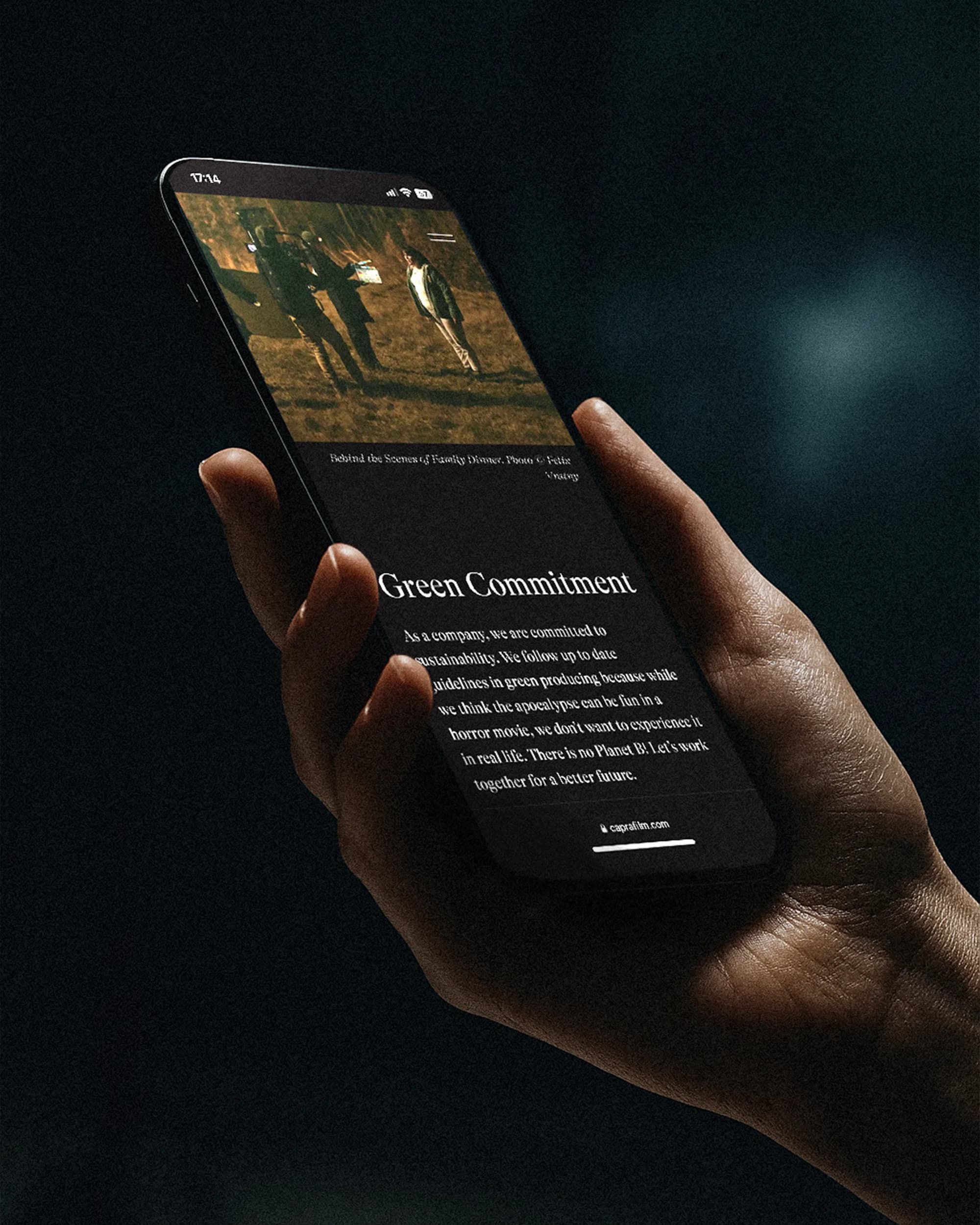 Hand hält ein Smartphone, auf dem die Website von Capra Film geöffnet ist